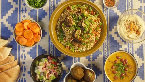 putting bulgur with eggplant top view. traditional middle eastern culture. delicious rice with meat. arabian cuisine. homemade food concept. bean soup, vegetable salad and hummus