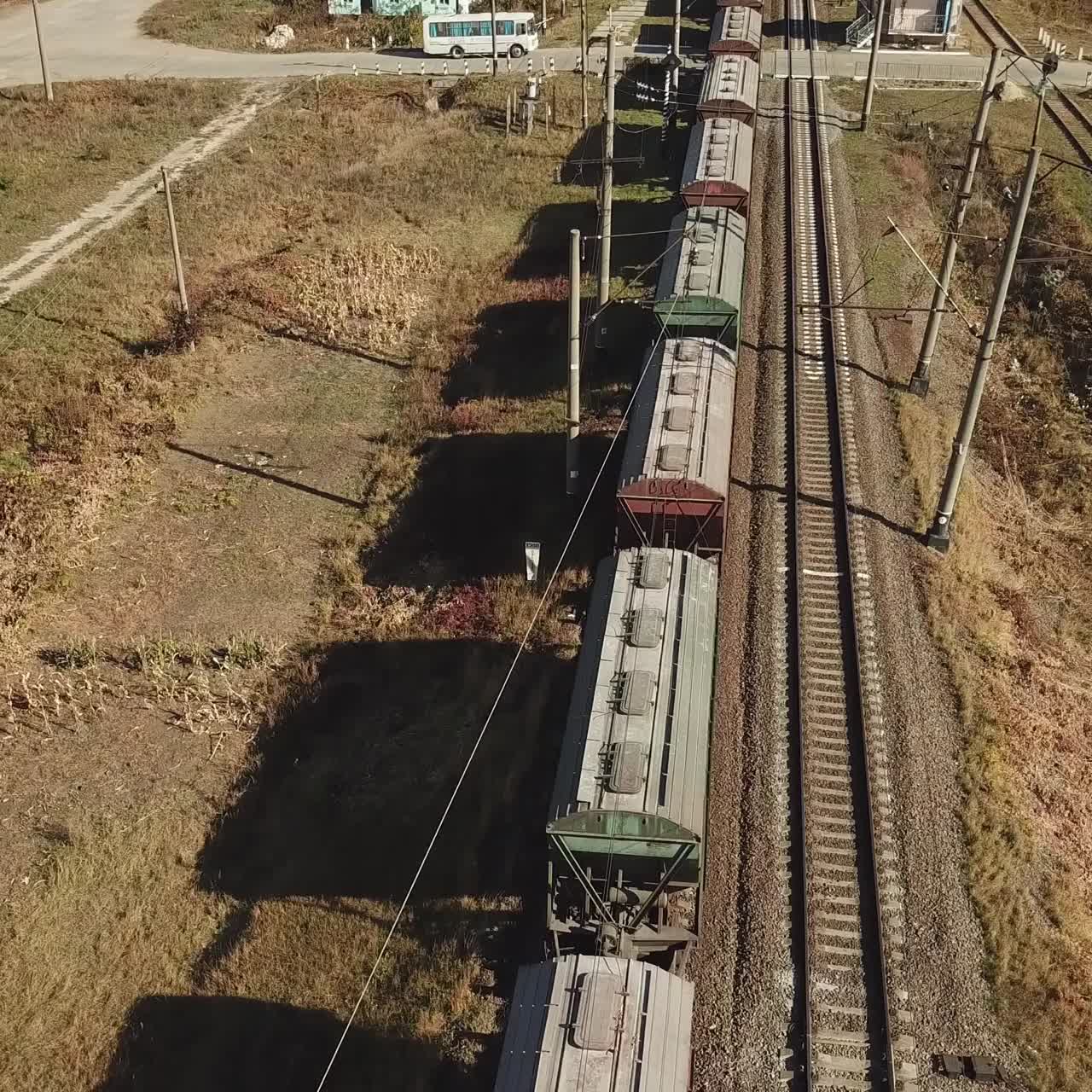 freight train is passing a highway. Aerial view of the freight train with wagons
