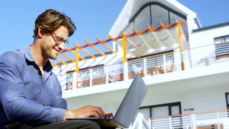 man using laptop in the porch 4k