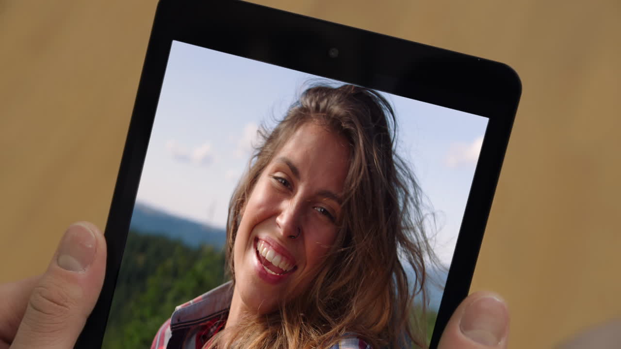 Homem fazendo chamada de vídeo com um tablet on-line em casa, close-up. Cara assistindo a um vídeo de viagem