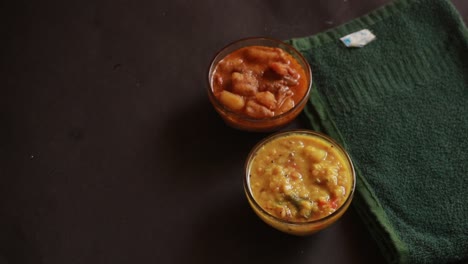 chole bhature o chick pea curry y puri frito servido en cerámica de terracota sobre un fondo negro