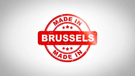 made in brussels signed stamping text wooden stamp animation. red ink on clean white paper surface background with green matte background included.