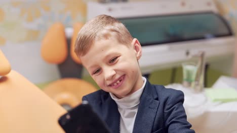 Retrato-De-Primer-Plano,-Niño-Tomando-Selfie-Por-Teléfono-En-El-Consultorio-Dental