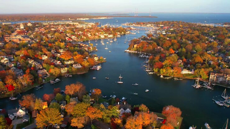 En time-lapse droneoptagelse af Annapolis havn med både på vandet og farverige efterårstræer