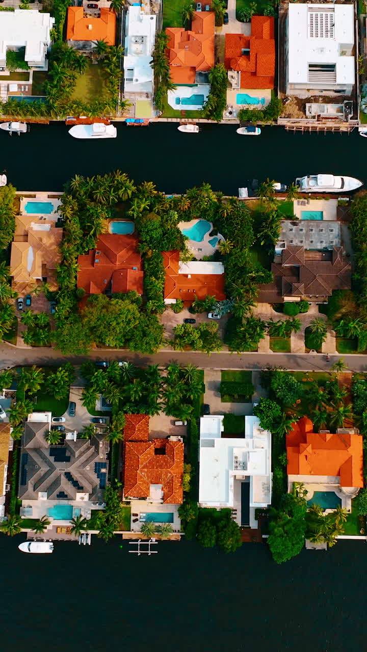 Residential area with luxurious houses and expensive yachts around the little island. Mansions of Miami, Florida, USA from top view. Vertical video