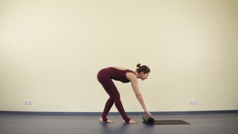 young attractive woman with flexible and fit body starts yoga practise on a black mat