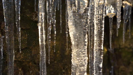 Vielzahl-Von-Langen-Gefrorenen-Eiszapfen-In-Einer-Nassen-Höhle,-Nahaufnahme,-Tschechien