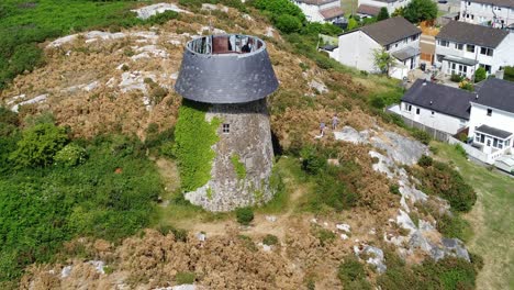 llangefni windmill ivy covered hilltop landmark aerial zoom in view overlooking welsh monument