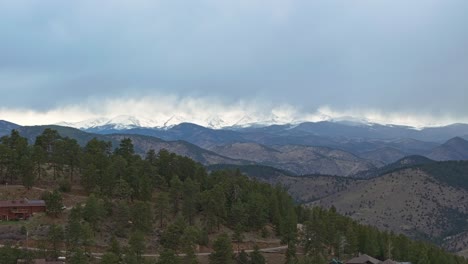 Gradual-aerial-ascend-above-mountain-homes-in-Colorado-surrounded-by-evergreen-trees