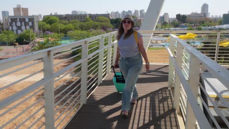 the traveler crosses a pedestrian bridge in the terminal, heading toward her gate.