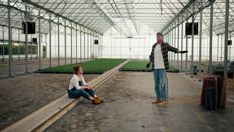 Confident-guy-Farmer-in-a-cap-tells-his-girlfriend-with-red-hair-How-they-will-arrange-a-greenhouse-on-the-farm