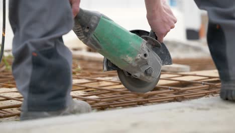 construction worker cutting fabricated steel bar for slab using abrasive cutting disc