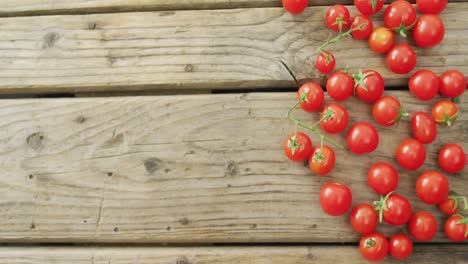 video of fresh cherry tomatoes with copy space on wooden background