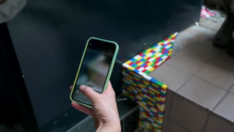 una mujer toma fotos y video mientras interactúa y toca el colorido juego de lego
