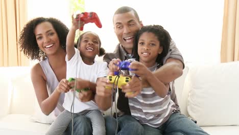 familia afroamericana jugando videojuegos en casa