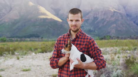 caucasian man looking at camera with his dog in his arms