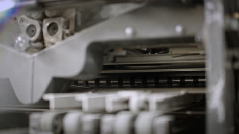 close up of a printing machine, paper moving on the production line, traveling on the right