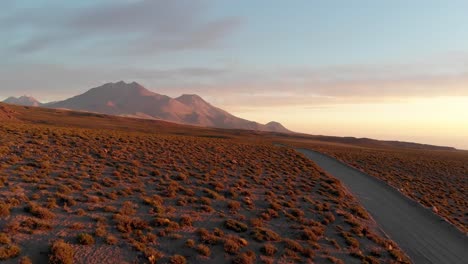 Aerial-cinematic-shot-of-a-dirt-road-in-the-Atacama-Desert,-Chile,-South-America