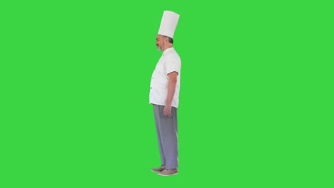 chef maduro de pie y hablando con alguien en una pantalla verde, clave de croma