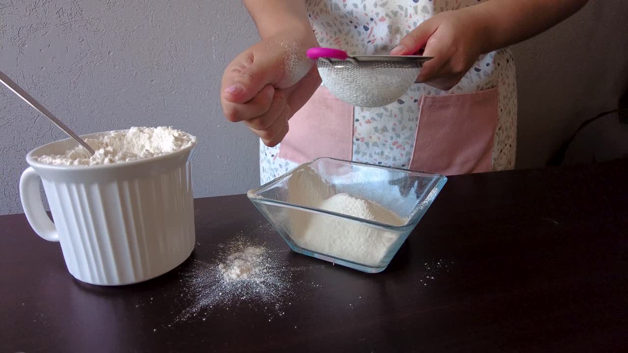 mujer latina con un delantal preparando la cocina horneando un pastel tamizando la harina con la mano y un colador de metal