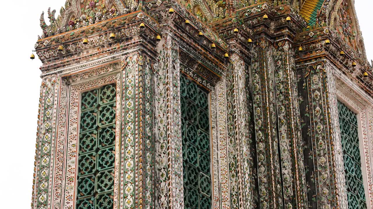 A detailed view of Wat Arun's ornate spire in Bangkok, showcasing intricate architecture and vibrant colors under natural daylight