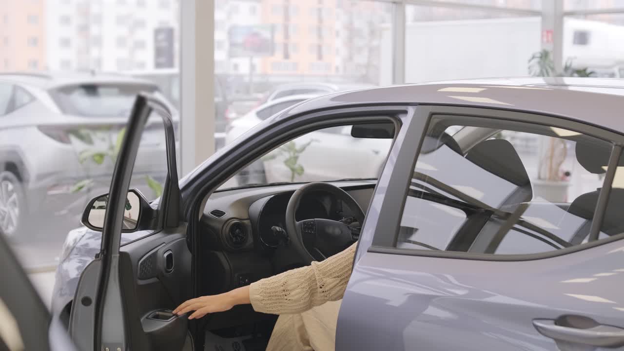 mujer eligiendo un coche en una sala de exposición de automóviles