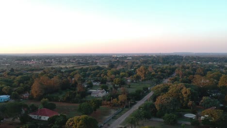 A-pull-down-drone-shot-of-a-densely-vegetated-neighborhood-in-Bulawayo,-Zimbabwe