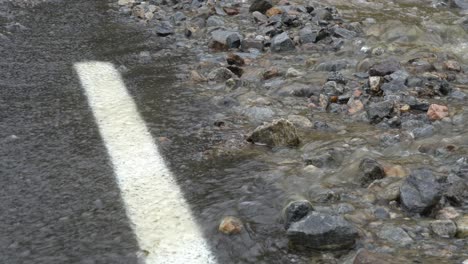 road overflowed with water during heavy rain - static closeup detail clip with flooding and climate change concept