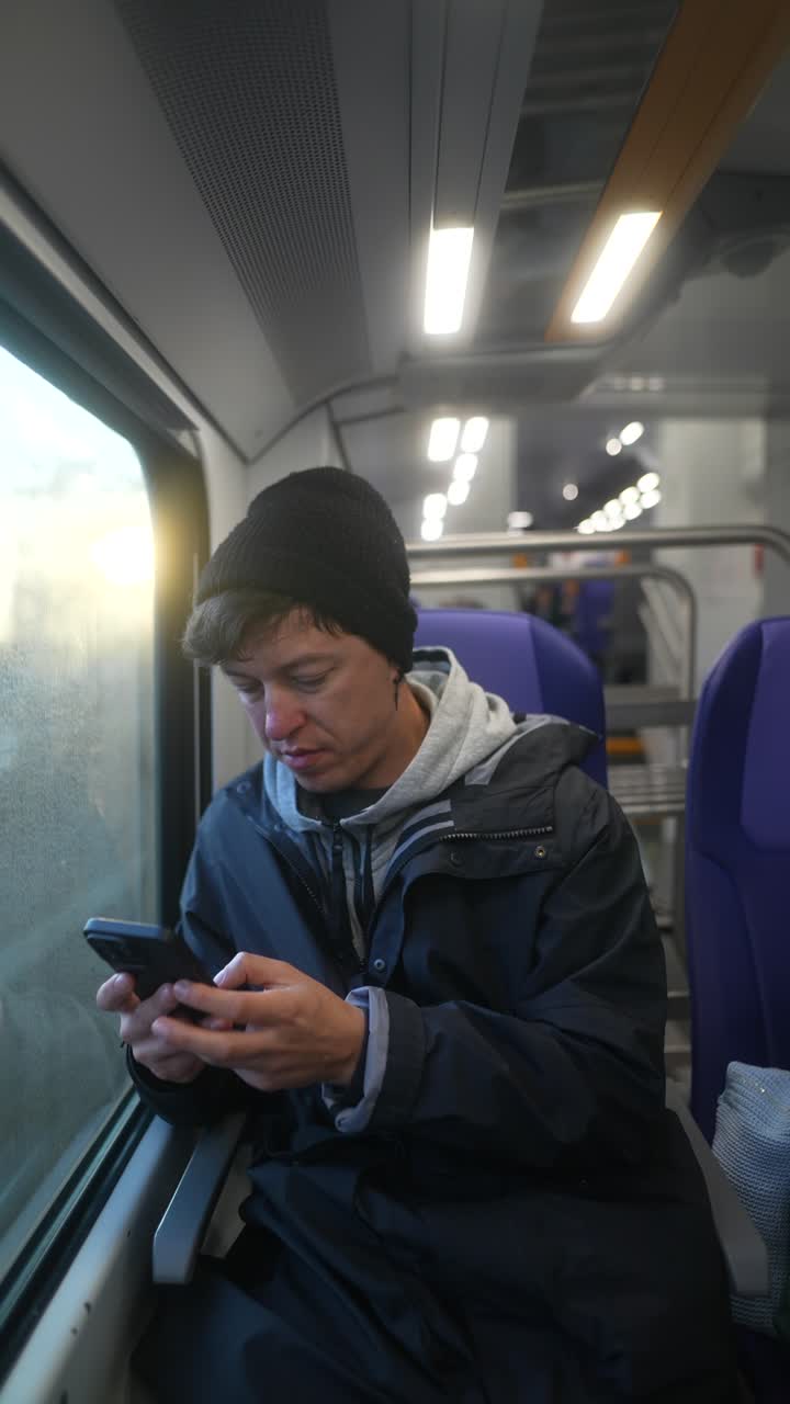 기차에서 스마트폰을 사용하는 남자