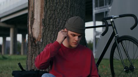 man sitting under a tree with a bicycle