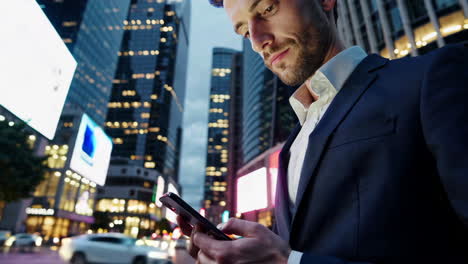 businessman using smartphone in a city at night