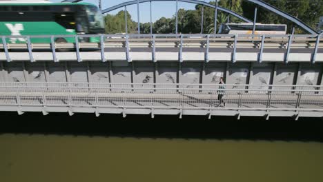 Overlooking-a-river-in-a-wooded-landscape-with-a-pedestrian-bridge-and-a-road-with-cars