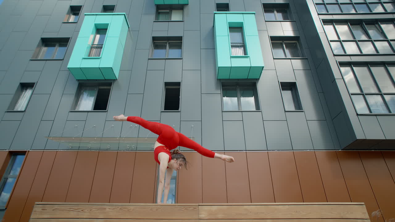 Woman Performing Acrobatics on Balcony