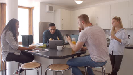 estudiantes relajándose en la cocina de un alojamiento compartido