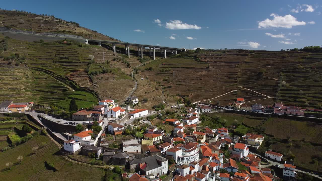 riprese con droni che volano via da un bellissimo villaggio tra le montagne vicino a porto in portogallo che mostrano la verde vallata ricoperta di vigneti