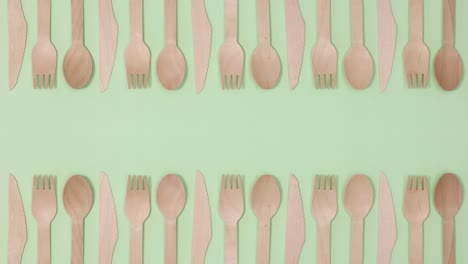 eco friendly zero waste eating utensil made of bamboo wood on two sides of green theme. stop motion