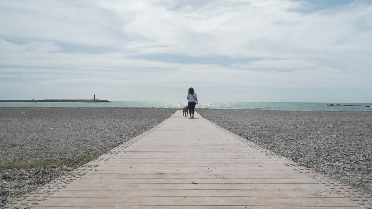 Girl with her boxer dog at the beach