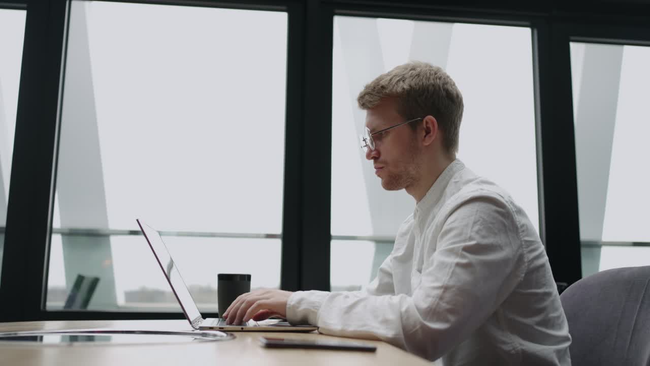 бизнесмен работает с ноутбуком в современном офисе или коворкинг-пространстве, просматривает интернет для получения информации