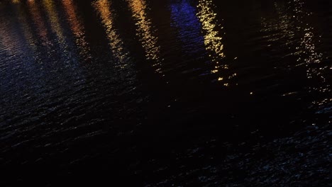 reflections of city lights on water at night