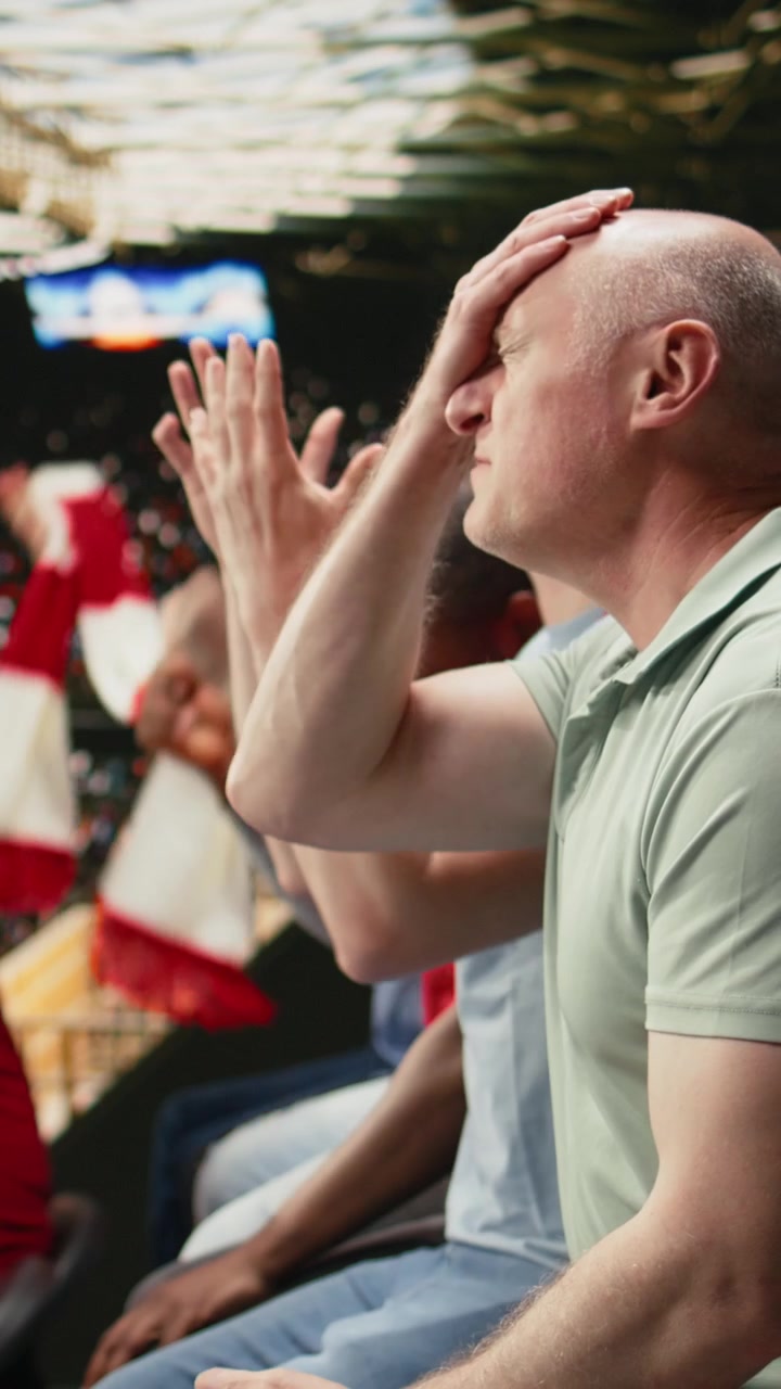 Vertikal video. Frustreret moden tilhænger taber et live betting væddemål på en mobil sportsbetting-app.
