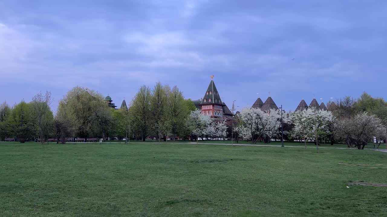 An ancient wooden castle surrounded by flowering trees