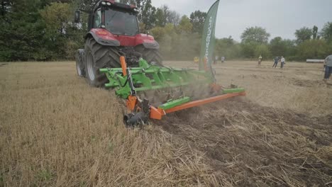 demostración de maquinaria agrícola en una exposición. los tractores operan en el campo, mostrando sus capacidades y rendimiento en acción