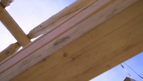 crane lifting wooden beams for house construction