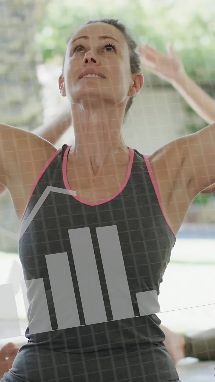 Vídeo vertical: Ao sinal, mulher madura levantando os braços em forma física, com o torso mostrando um gráfico e interface binária.