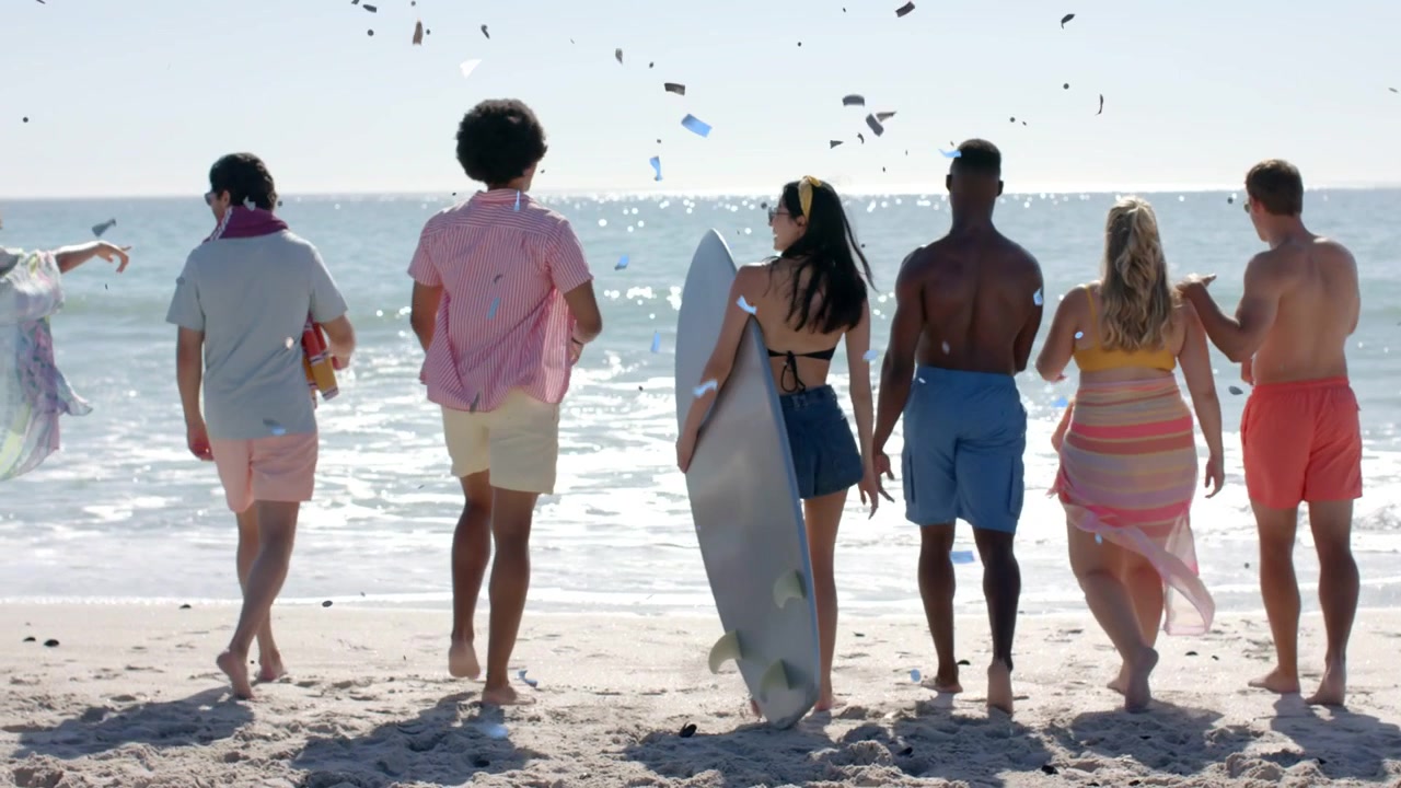 Travelers heading to surf while woman carrying surfboard, person raising arm causing paper