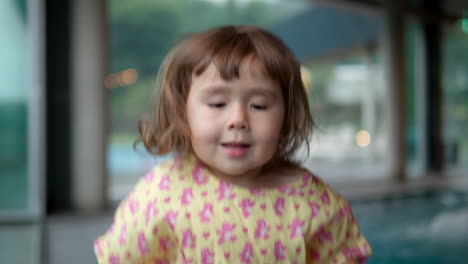 Funny-Happy-Little-Girl-Jumps-and-Twirl-Excited-on-Vacation-At-Luxury-Hotel-by-Jacuzzi-Pool