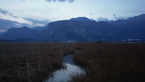 Paisaje-Escénico-Aéreo-De-Las-Montañas-Canadienses-Con-Una-Corriente-De-Agua-Estrecha-En-El-área-De-Conservación-Del-Estuario-Del-Río-Squamish-Spit