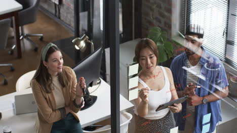 Young-Caucasian-woman-and-Asian-woman-discuss-business-with-young-Asian-man-in-an-office-setting