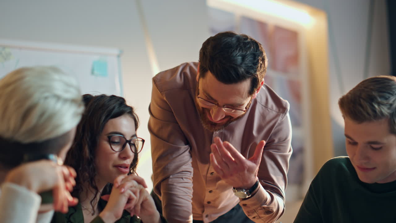 Smiling business team planning work day at morning meeting in conference room.