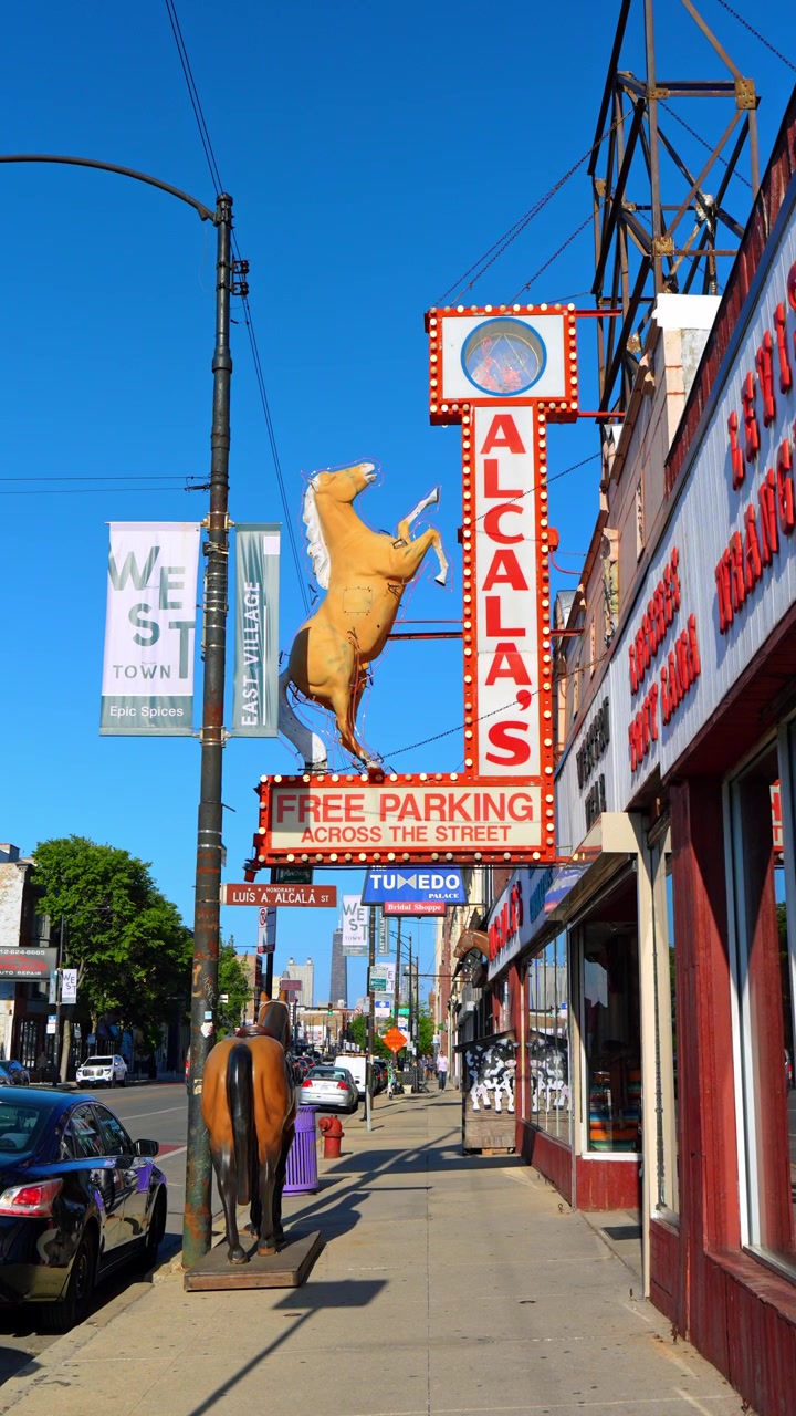 Chicago, USA, 9 maggio 2026: Insegna con cavallo di Alcalas Western Wear a West Town Chicago. Vista stradale verticale mostra l'insegna illuminata del negozio, figure di cavalli, vetrine, auto parcheggiate e cielo blu.